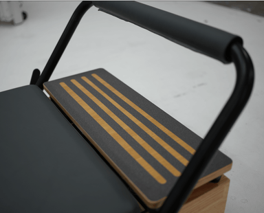 Wooden platform extender with black non-slip integration to extend the Pilates reformer.