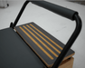 Wooden platform extender with black non-slip integration to extend the Pilates reformer.