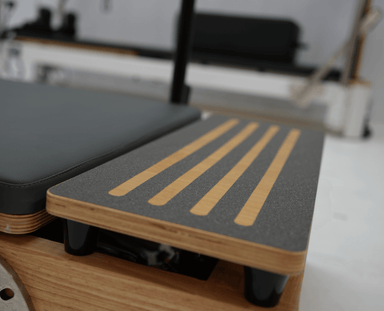 Side view of platform extender on the core collab foldable Pilates reformer.