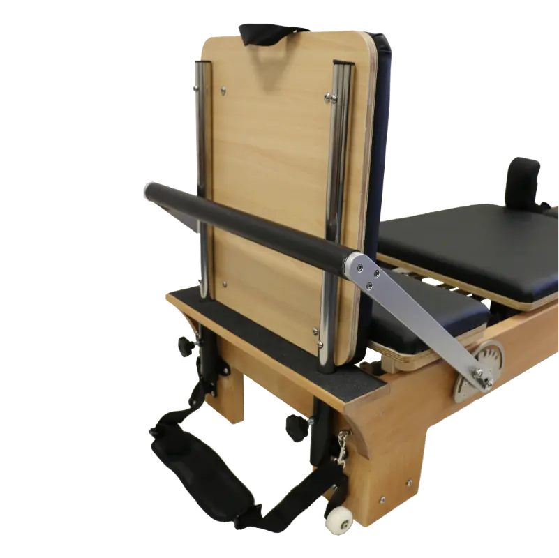 close up of foot end of wooden reformer pilates machine showing white wheels, adjustable footbar and jump board attachment.