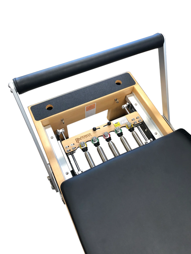 close up of wooden pilates reformer with black upholstery, showing 5 colour coded springs.