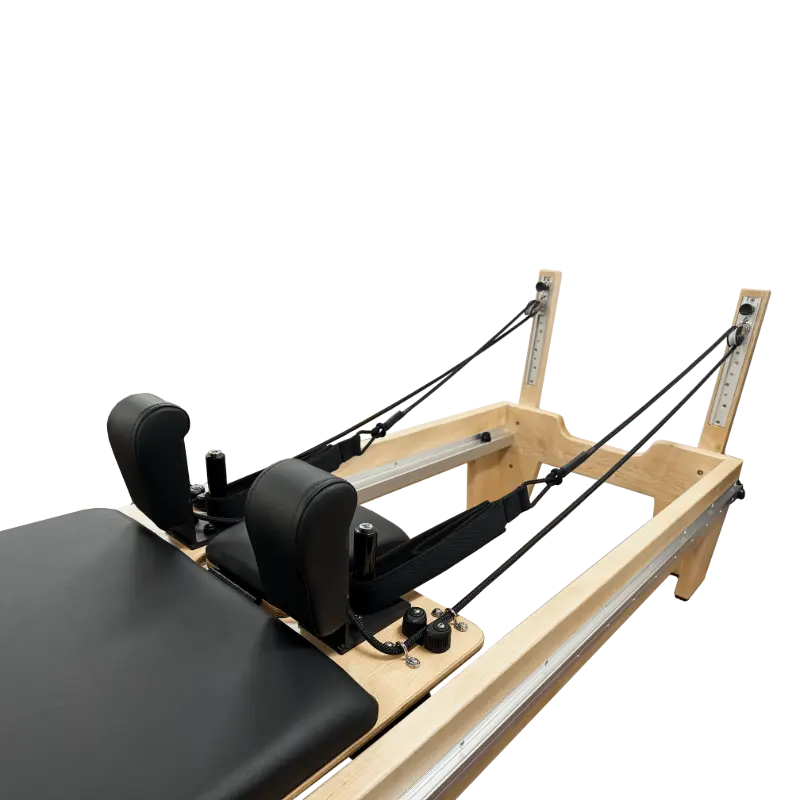 Close up of clinical pilates reformer with black upholstery at the shoulder and head cushions.