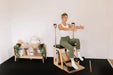 Woman using a premium Pilates Wunda Chair in a studio setting.