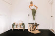 Woman using a premium Pilates Wunda Chair in a studio room.