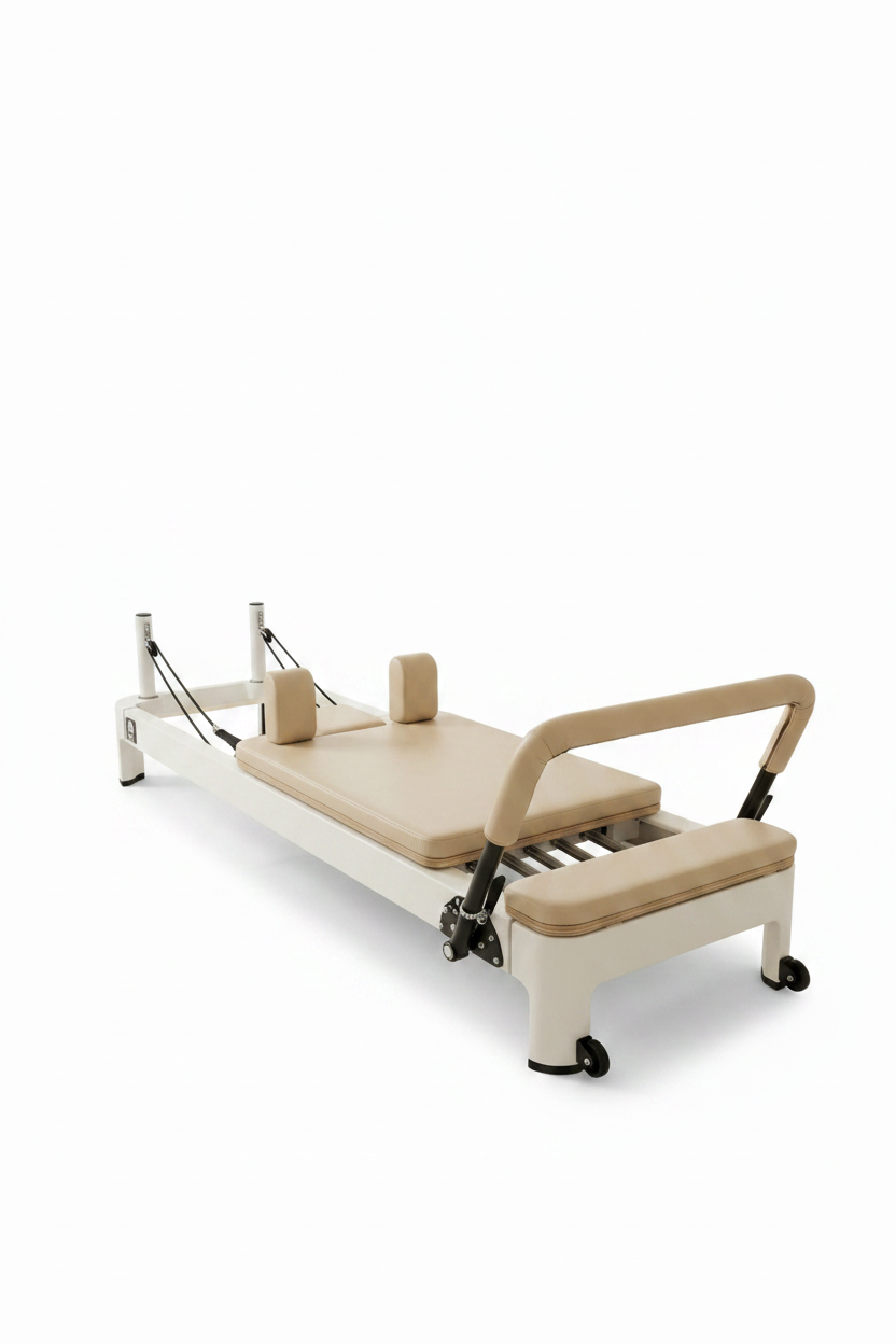 Core Collab Queen 2.0 Pilates reformer with white frame and beige upholstery in a studio setting with an arched window.
