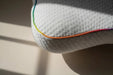 Close up of a kids Blackroll recovery pillow showing the white textured material and rainbow border.