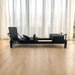 Core collab queen reformer in black frame and upholstery in lounge room with light wooden floors and sheer curtains. 